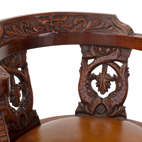 Antique heavily carved fully rotating oak ships chair with tan leather seat (c.1880)